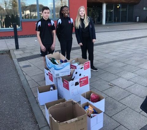 Three Leigh Academy students are pictured standing outside Darent Valley Hospital with some boxes of donated food for NHS frontline staff.