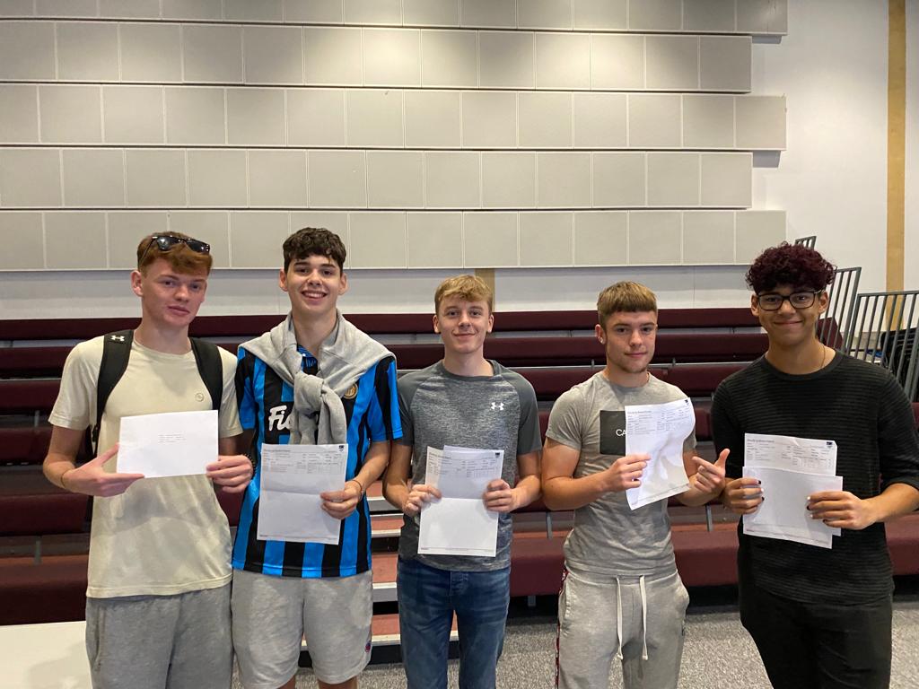 A group of male Post-16 students are seen stood together with their results sheets, smiling for the camera on A Level Results Day 2022.