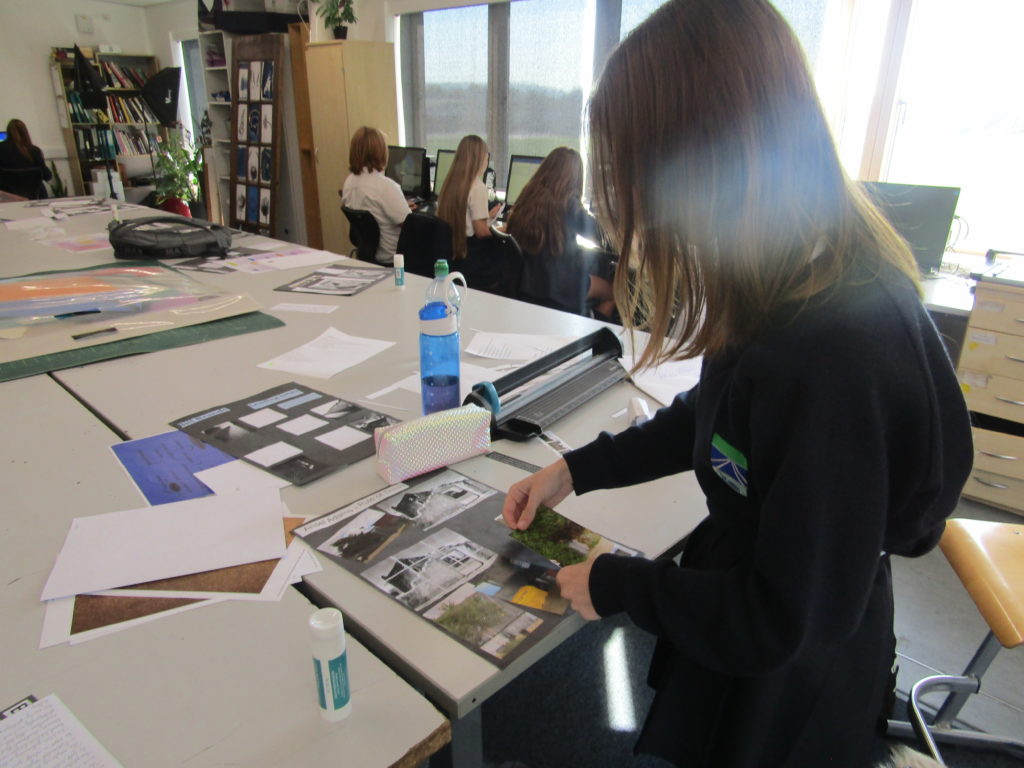 A female Leigh Academy student is seen using a glue stick to create a collage of images during an Art class.