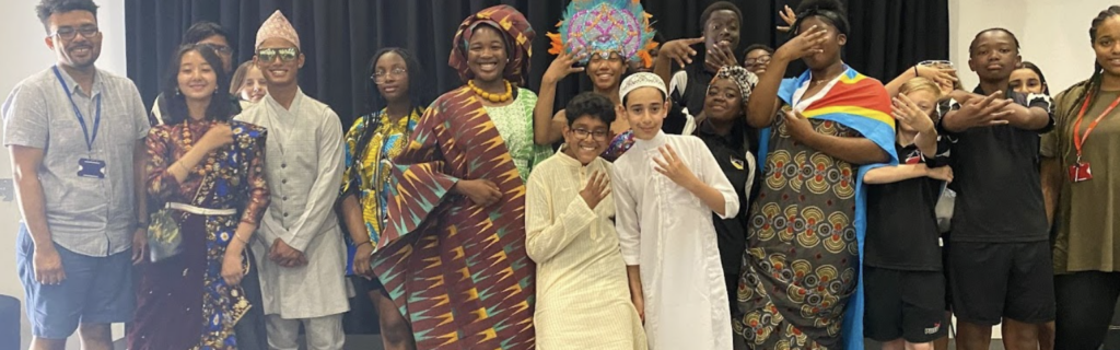 A group of Leigh Academy students are pictured standing alongside adults whilst dressed up in African and Asian traditional clothing.
