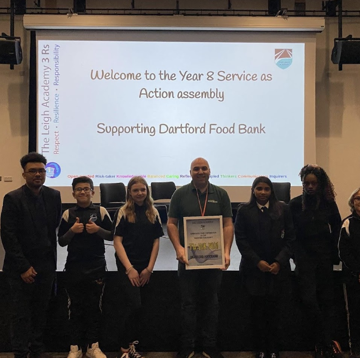Several students are seen posing for the camera, alongside a member of staff at an assembly supporting Dartford Food Bank.