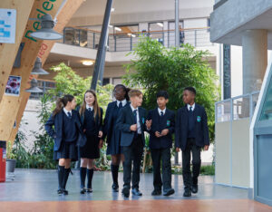A small group of six Leigh Academy students, three male, three female, can be seen walking around the academy building and conversing with one another.